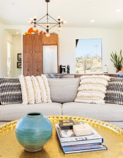 Brightly lit living room with modern furnishings and a blue decorative vase on a yellow coffee table.