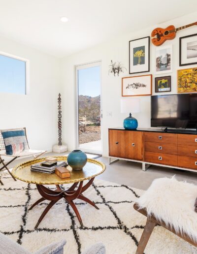 Bright, modern living room with eclectic decor and large window.