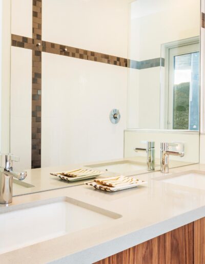 Modern bathroom with dual sinks and a scenic desert view through the window.