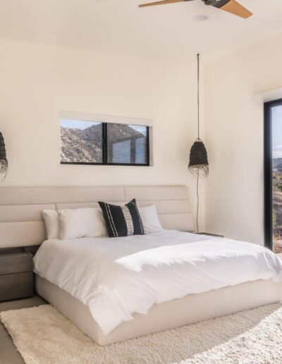 Modern bedroom with large window offering a desert view.