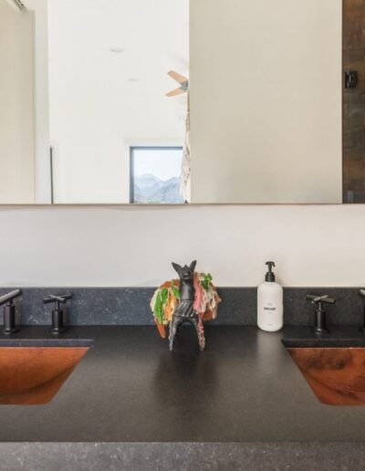 Modern bathroom interior with dual copper sinks and mountain view.