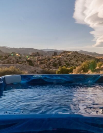 Hot tub with a view of desert landscape at sunset.