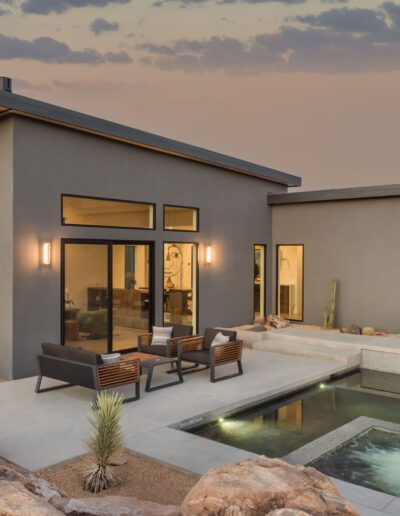 Modern desert home with outdoor pool at dusk.