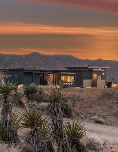 Modern desert home against a backdrop of a dramatic sunset.