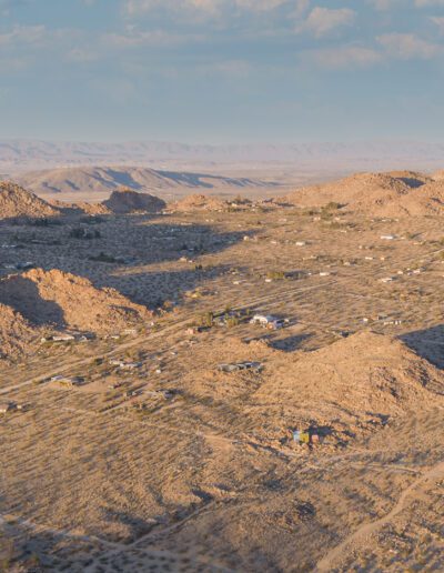 Arid landscape with scattered residential areas at the foothills of desert hills.