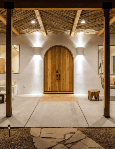 Elegant rustic-style interior with a large wooden door, exposed beams, and thatched ceiling.