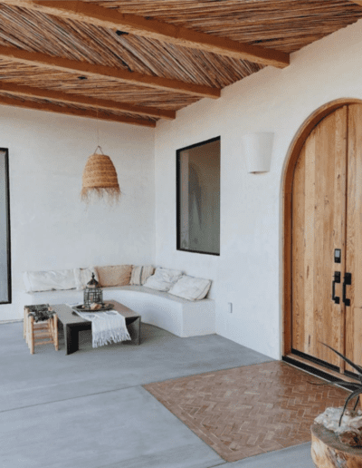 Rustic patio area with a built-in seating nook, wooden door, and exposed beam ceiling.