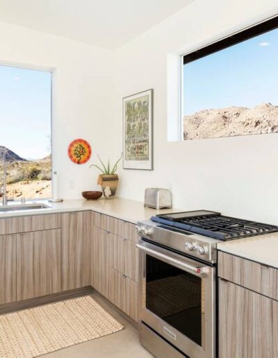 Modern kitchen corner with wooden cabinetry and stainless steel oven.